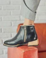 Bota corta de cuero negro con cierre lateral y suela de madera.