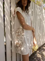 Vestido corto gris con bordado floral en el frente, corte holgado y mangas cortas.