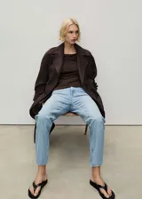 Jeans mom fit de tiro alto, color celeste claro, con cinco bolsillos y cierre frontal con cremallera y botón.