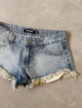 Short de jean celeste claro con cintura baja y flecos en el ruedo.