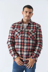 Sobrecamisa de algodón para hombre con interior de corderito, estampado a cuadros en tonos negro, blanco y azul. Tiene cierre de botones, bolsillos tipo cartera y logo en goma. El modelo usa talle M.