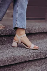 Sandalias de tacón bajo color beige con textura símil piel de serpiente. Tienen una tira delgada sobre los dedos y una pulsera con hebilla al tobillo.