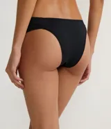 Kit de dos bombachas de bikini sin costuras, confeccionadas en microfibra, con forro. Incluye una bombacha blanca con laterales fruncidos y una bombacha negra con moño decorativo.