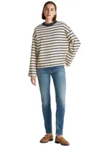 Jean de mezclilla elástica de algodón, color azul medio con efecto desteñido y arrugado. Presenta un corte ajustado y cintura media, con cierre de cremallera y botón, y estilo de cinco bolsillos.