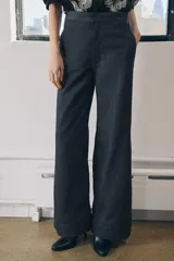 Pantalón de jean azul oscuro, de tiro medio, corte wide leg y bolsillos laterales.
