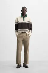 Polo de corte relajado confeccionado en tejido de punto con textura de chenilla. Presenta cuello de solapa con cierre frontal de botonadura, mangas largas y acabados en rib.
