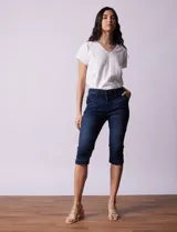 Pantalón capri blanco de algodón elastizado. Pretina con pasadores, botón y cierre. Delantera con bolsillos. Trasera con bolsillos simulados.