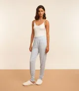 Pantalón de pijama celeste con estampado de patitas blancas, cintura elástica y puños ajustados.