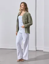 Camisa blanca de algodón con textura arrugada, cuello con solapa, abertura central con botones y bolsillo aplicado en el pecho. Mangas largas con largo regulable mediante presilla y botón.
