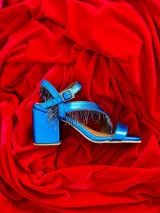 Sandalias de gamuza azul con taco cuadrado y tiras con flecos azules.