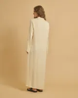 Vestido largo color crema, con cuello mao con lazo ajustable, mangas largas amplias y tajos laterales.