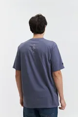 Remera marrón de manga corta con cuello redondo y estampado con texto en el frente.