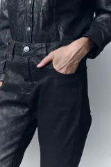Pantalón de jean skinny tiro alto en denim con elastano, con pierna ajustada hacia el tobillo. En denim negro con elastano y un proceso de coating marrón que brinda una apariencia similar al cuero. Sobre el mismo un diseño en laser animal print. Con cierre y botón.