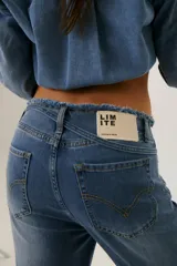 Pantalón de jean acampanado de tiro alto, color azul, con cintura desflecada y lazo ajustable.