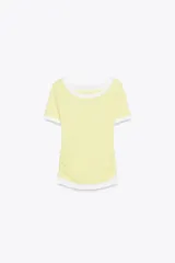 Camiseta blanca de corte slim fit, cuello redondo y manga corta con acabados en puntilla. Tiene detalle de frunces en los laterales y tejido combinado a contraste efecto doble en cuello, mangas y ruedo.