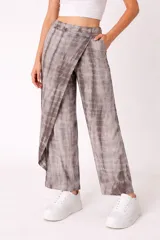 Pantalón de mujer color gris con estampado tie-dye, corte recto y diseño cruzado en la parte delantera.