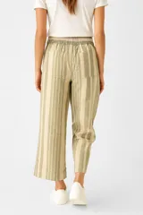 Pantalón capri de lino a rayas verticales en tonos beige y marrón, con cintura elástica ajustable con cordón.