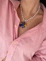 Collar corto de perlas blancas con mostacillas de colores y dije de vidrio con forma de pez azul, amarillo y naranja.