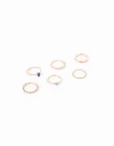 Set de seis anillos dorados con detalles de esmalte, strass y piedras de diferentes colores.