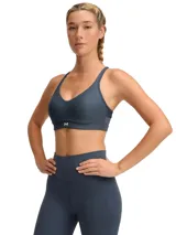 Top deportivo de sujeción baja, color gris azulado, con breteles finos y espalda deportiva.