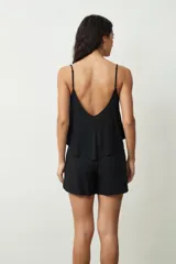 Conjunto de top y short con estampado de piel de serpiente en tonos beige y negro. El top es de tirantes finos y corte holgado. El short es de corte holgado con cintura elástica ajustable.