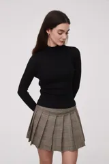 Polera de punto negro con cuello alto y manga larga, con diseño acanalado y ajuste ceñido.