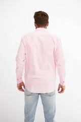 Camisa de hombre color crema, de corte clásico, con cuello abotonado y mangas largas.