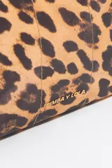Neceser mediano Bimba y Lola con exterior de nylon y estampado animal print. Tiene estructura blanda, cierre con cremallera, bolsillo interior y placa metálica con el logo.