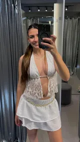 Top blanco de encaje con escote halter y espalda descubierta.