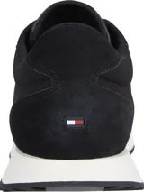 Zapatillas de running Tommy Hilfiger color negro, con detalles de cuero y gamuza. Presentan una suela dentada blanca y una franja tricolor en el lateral.