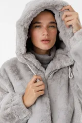 Campera de abrigo color gris, con capucha y cierre frontal, confeccionada en material suave.
