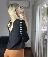 Blusa negra de crepé de lino con escote en V, mangas 3/4 con hombreras y detalle fruncido en los hombros. Se ata en la espalda con tiritas.