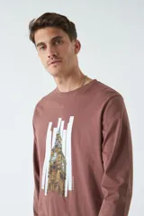 Remera blanca de manga larga con cuello redondo y estampado de un edificio antiguo.