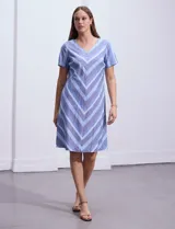 Vestido azul con estampado de líneas diagonales, escote en V y mangas cortas.