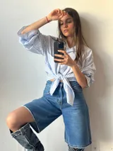 Bermuda de jean azul con corte a la rodilla y terminación desflecada.