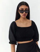 Top turquesa con escote cuadrado, mangas abullonadas y cuerpo fruncido.