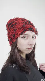 Gorro de lana tejido a crochet con diseño abstracto en rojo y negro.