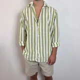 Camisa de lino a rayas verticales color beige y blanco, de corte holgado y manga larga con puños abotonados.