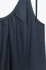 Top azul de popelina con escote redondo, tirantes finos con lazadas y detalle de pliegues.