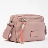 Bandolera color rosa con correa larga regulable y cierre superior. Tiene un bolsillo frontal con cierre y un dije decorativo colgando.