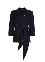 Blusa azul marino con estampado de lunares blancos, cuello camisero, mangas 3/4 y lazo en la cintura.