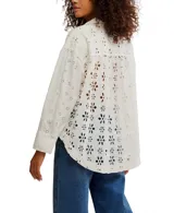 Camisa blanca de algodón con bordado calado, corte relajado, cuello con muescas, cierre frontal con botones, mangas largas con hombros caídos y puños.