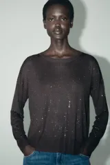 Sweater de punto calado color blanco, de corte holgado, cuello redondo y manga larga.