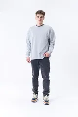 Buzo deportivo gris melange de corte clásico con cuello redondo y mangas largas.