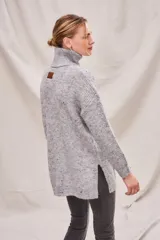 Sweater beige con cuello alto doble, textura acanalada y tajos laterales.