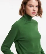 Blusa de punto color blanco, con cuello alto, manga larga y diseño liso.