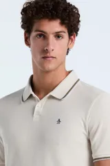Polo de hombre color beige claro, de manga corta, con cuello y puños ribeteados en color marrón oscuro. Presenta un pequeño logo bordado en el pecho.