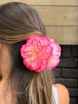 Pinza para el pelo con flores rojas de tela.
