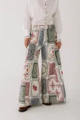 Pantalón jean wide leg con estampado de cartas de póker y dados.