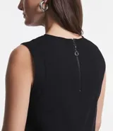 Blusa sin mangas color celeste, de crepé, con cuello redondo, pliegues en uno de los hombros y cierre trasero por cremallera con detalle de aro en el tirador.